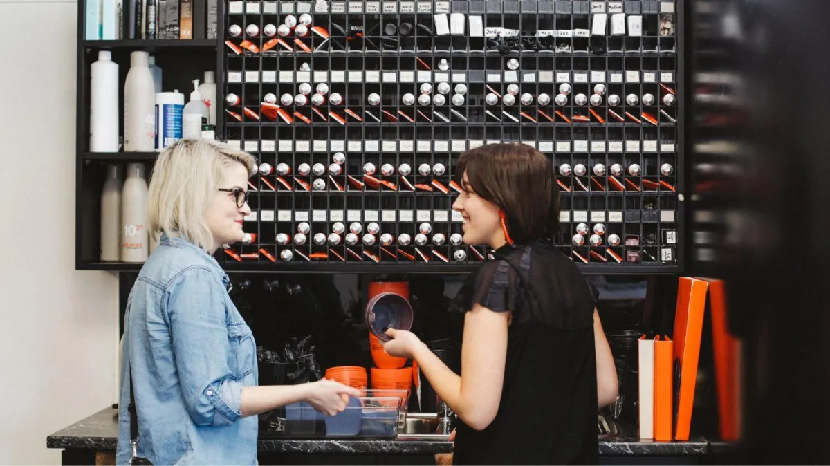 Two salon professionals discussing colour products at the colour bar